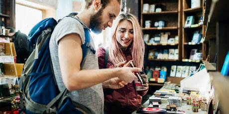 Two Young Backpackers Exploring A Store Together