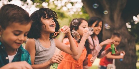 Seifenblasen-Spaß Kinder spielen mit Seifenblasen