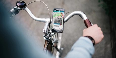 Fahrradtour zum Kriegsende auf der ABOUT BERLIN App Fahrradroute Kriegsende - Mockup Fahrrad mit Handy