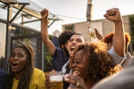 Party beim Fussball Mehrere junge Menschen schauen Fussball und jubeln