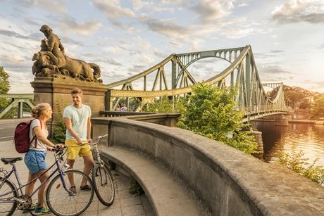Bicycle tour at Glienicke Bridge Bicycle tour man and woman near Glienicke Bridge in Berlin
