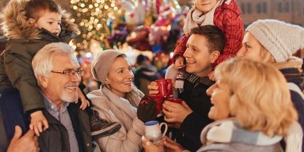 Familie auf dem Weihnachtsmarkt Glückliche Familie auf dem Weihnachtsmarkt