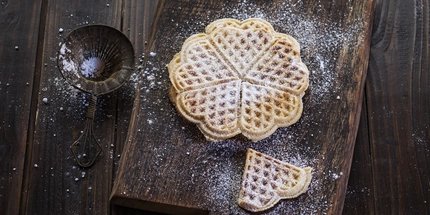 Waffeln mit Puderzucker auf einem Holzbrett Waffeln mit Puderzucker auf einem Holzbrett