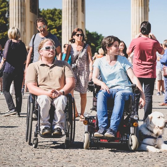 Brandenburger Tor Two visitors in a wheel chair in front of the Brandenburger Tor