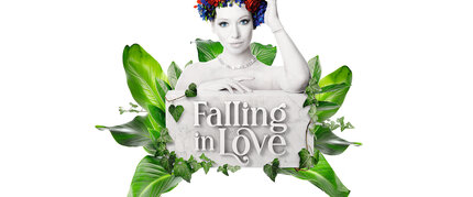 Eine Frau in Graustufen mit geblümtem Kopfschmuck posiert hinter einem Schild mit der Aufschrift "Falling in Love", umgeben von grünen Blättern.