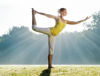 Frau praktiziert Yoga im Park