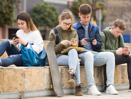 Jugendliche, die auf ihre mobilen Telefone schauen