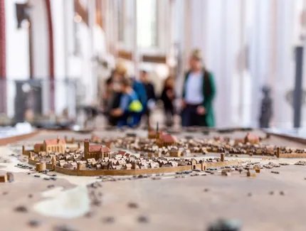 Modell der mittelalterlichen Stadt Berlin im Museum Nikolaikirche, im Hintergrund unscharf Besucher und das Innere des Kirchenschiffs Modell der mittelalterlichen Stadt Berlin im Museum Nikolaikirche, im Hintergrund unscharf Besucher und das Innere des Kirchenschiffs