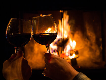 Verres à vin devant un feu de cheminée