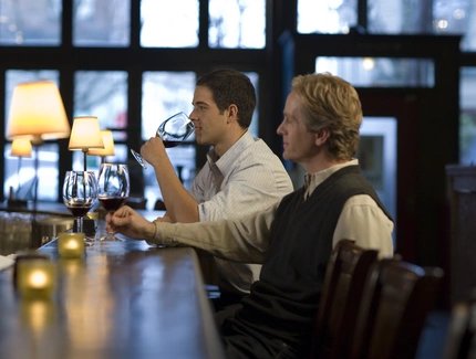 Two men sitting at a bar drinking wine Two men sitting at a bar in Berlin drinking wine