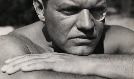 Schwarz-Weiß-Fotografie von Raoul Hausmann, der mit runder Sehhilfe im linken Auge, den Kopf auf den verschränkten Armen aufgelegt, an den Betrachtenden vorbei in die Ferne blickt. Schwarz-Weiß-Fotografie von Raoul Hausmann, der mit runder Sehhilfe im linken Auge, den Kopf auf den verschränkten Armen aufgelegt, an den Betrachtenden vorbei in die Ferne blickt.