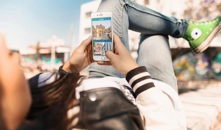 Young woman uses street art highlight of the ABOUT BERLIN app. Young woman uses street art highlight of the ABOUT BERLIN app.