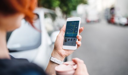 Car sharing: woman in Berlin uses app on her smartphone Car sharing: woman in Berlin uses app on her smartphone