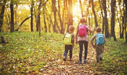 Kinder im Wald in Berlin Drei Kinder mit Rucksäcken im Wald