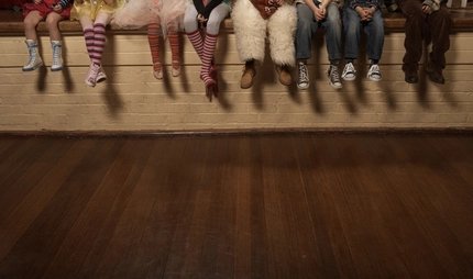 Kinder sitzen auf einer Theaterbühne