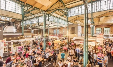 Inside the market hall Markthalle Neun Visitors in the market hall Markthalle Neun in Berlin Kreuzberg