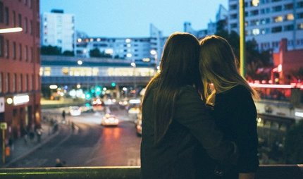 Ein Lesbisches Paar im Berliner Nachtleben Lesbisches Paar umarmt sich und guckt in Richtung Stadt