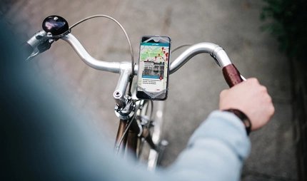 Fahrradtour zum Kriegsende auf der ABOUT BERLIN App Fahrradroute Kriegsende - Mockup Fahrrad mit Handy