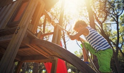 Ein Junge beim klettern auf dem Spielplatz
