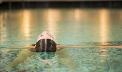 A woman relaxes in the pool of a day spa