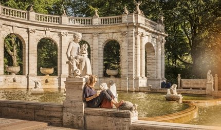 The fairytale fountain in the Volkspark Friedrichshain A woman reads at the fairytale fountain in the Volkspark Friedrichshain