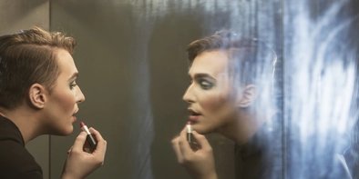 Dragqueen in Berlin Drag queen makes up in front of the mirror in Berlin