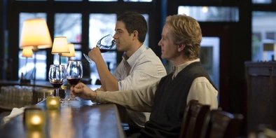 Two men sitting at a bar drinking wine Two men sitting at a bar in Berlin drinking wine